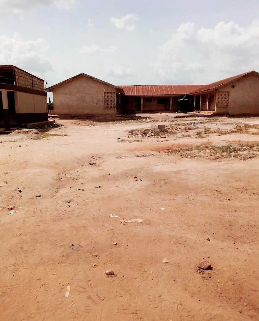 Exterior view of a school building and surrounding grounds in Ghana.