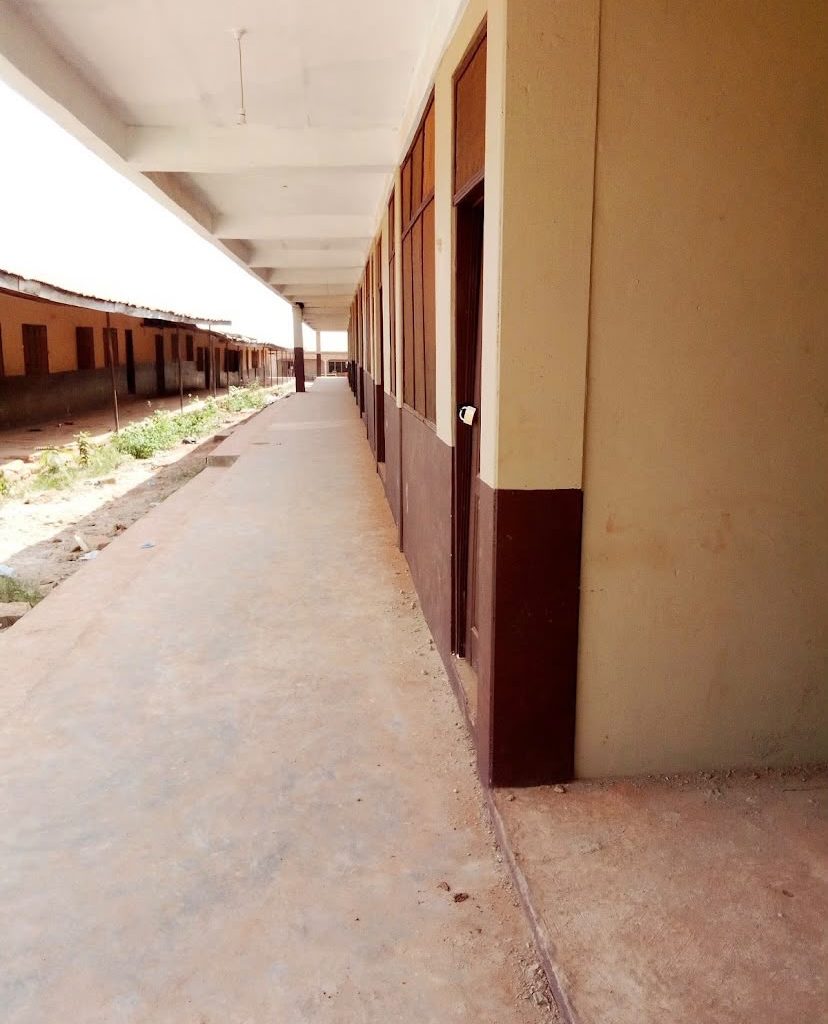 Exterior view of a school building and surrounding grounds in Ghana.