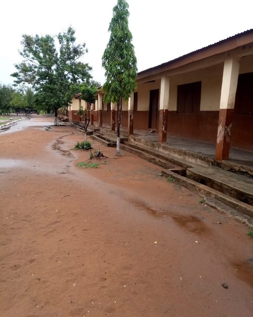 Exterior view of a school building and surrounding grounds in Ghana.